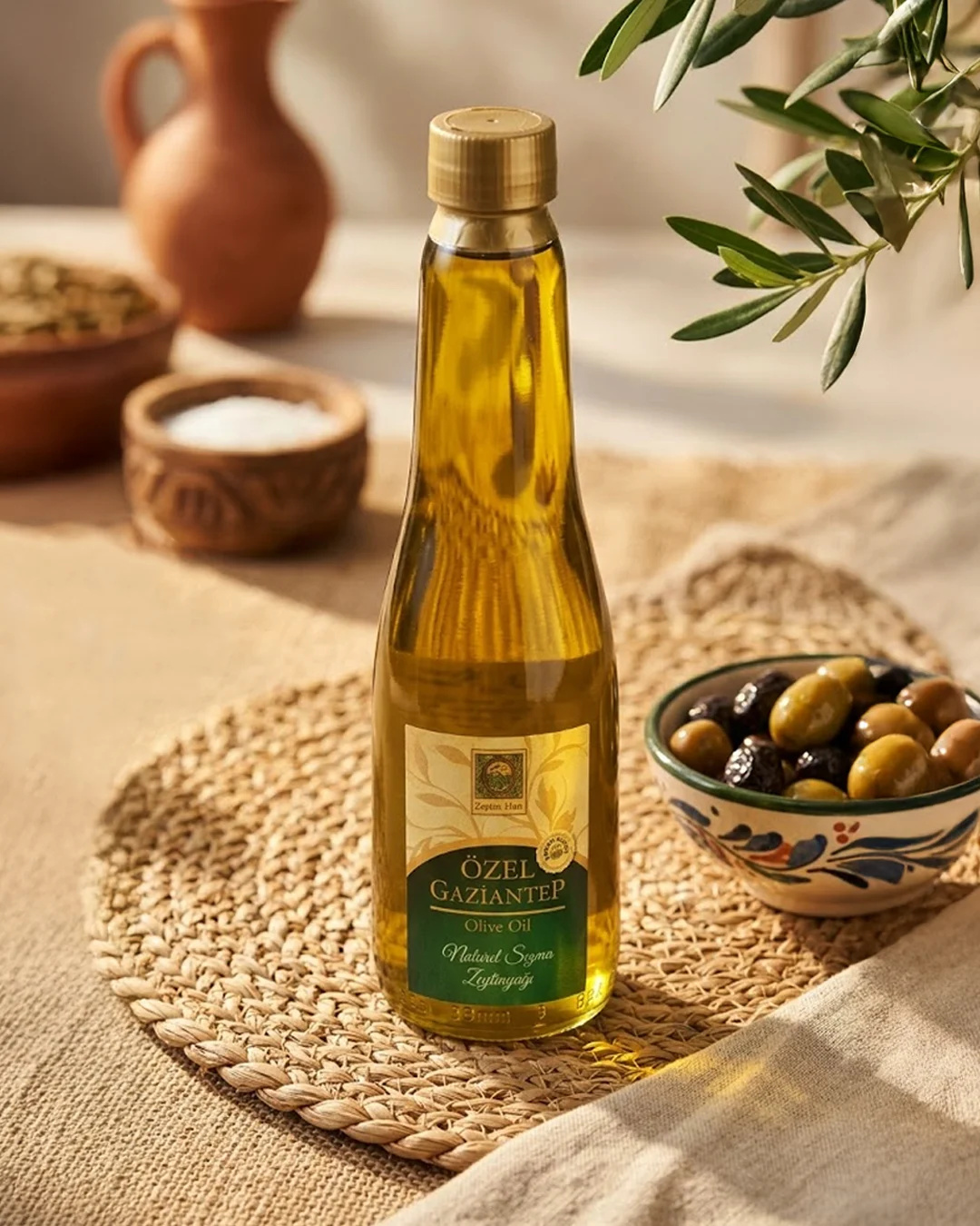 Zeytin kasesinin yanında Zeytin Han zeytinyağı şişesi