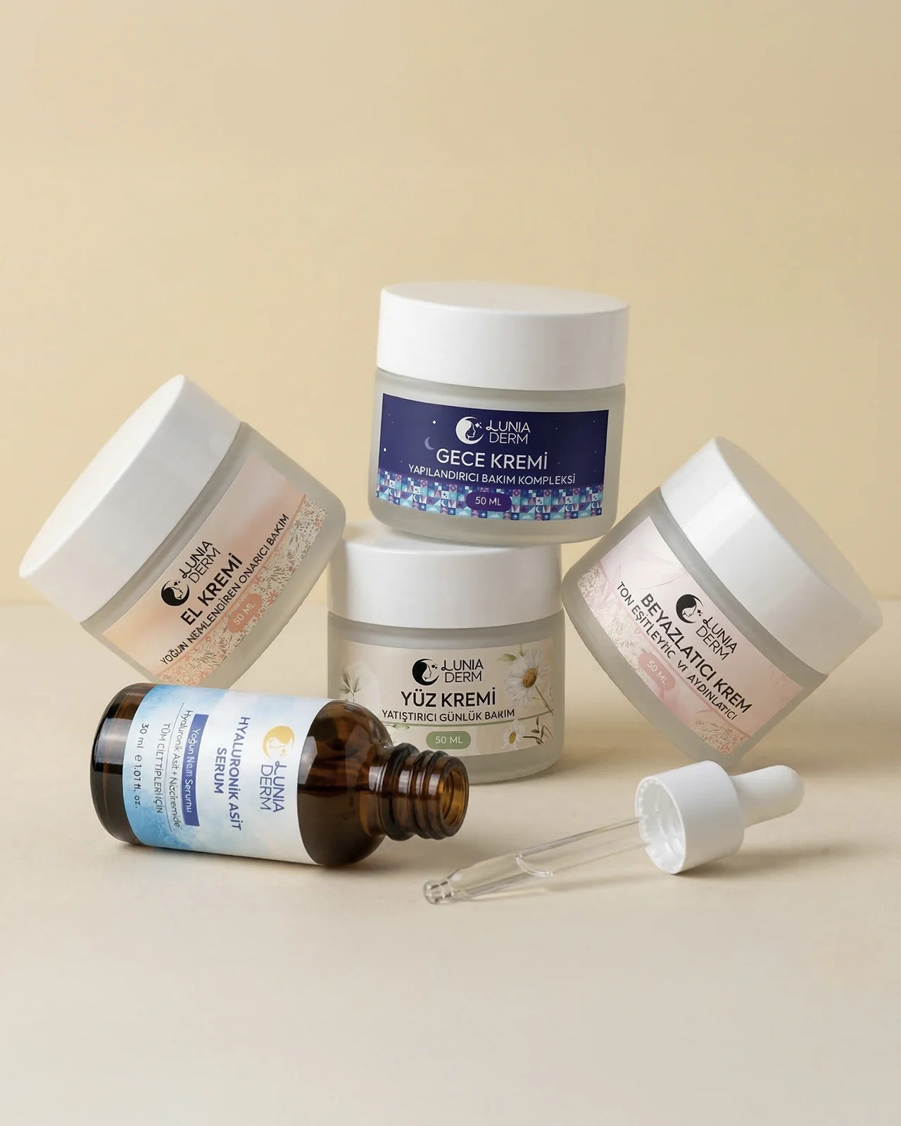 Lunia Derm el, gece, yüz ve beyazlatıcı krem kavanozları ile hyaluronik asit serum şişesi
