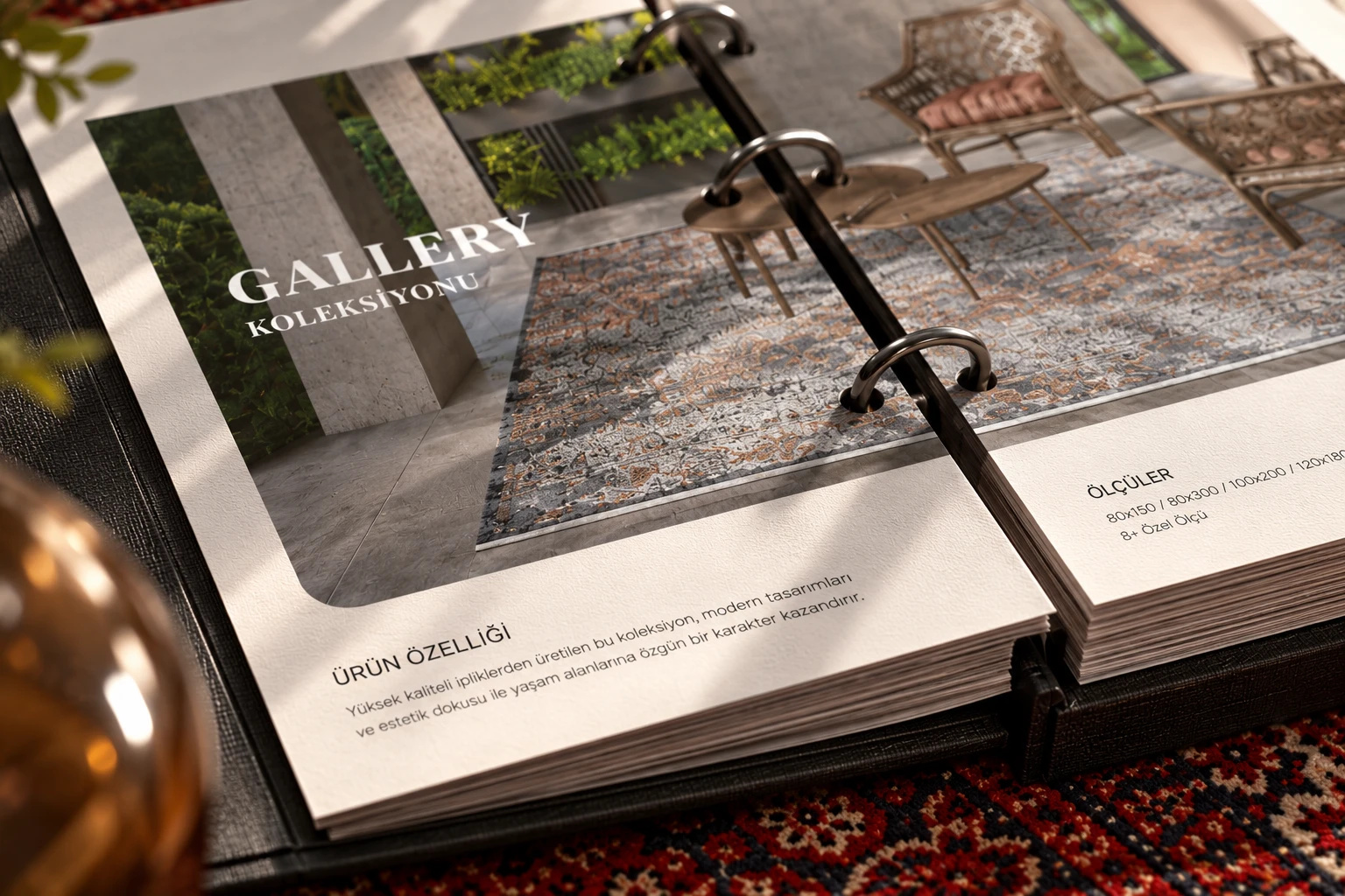 A closer look at the Gallery Collection spread of the ring-bound catalogue: a grey and copper rug on a planted terrace, product details and sizes