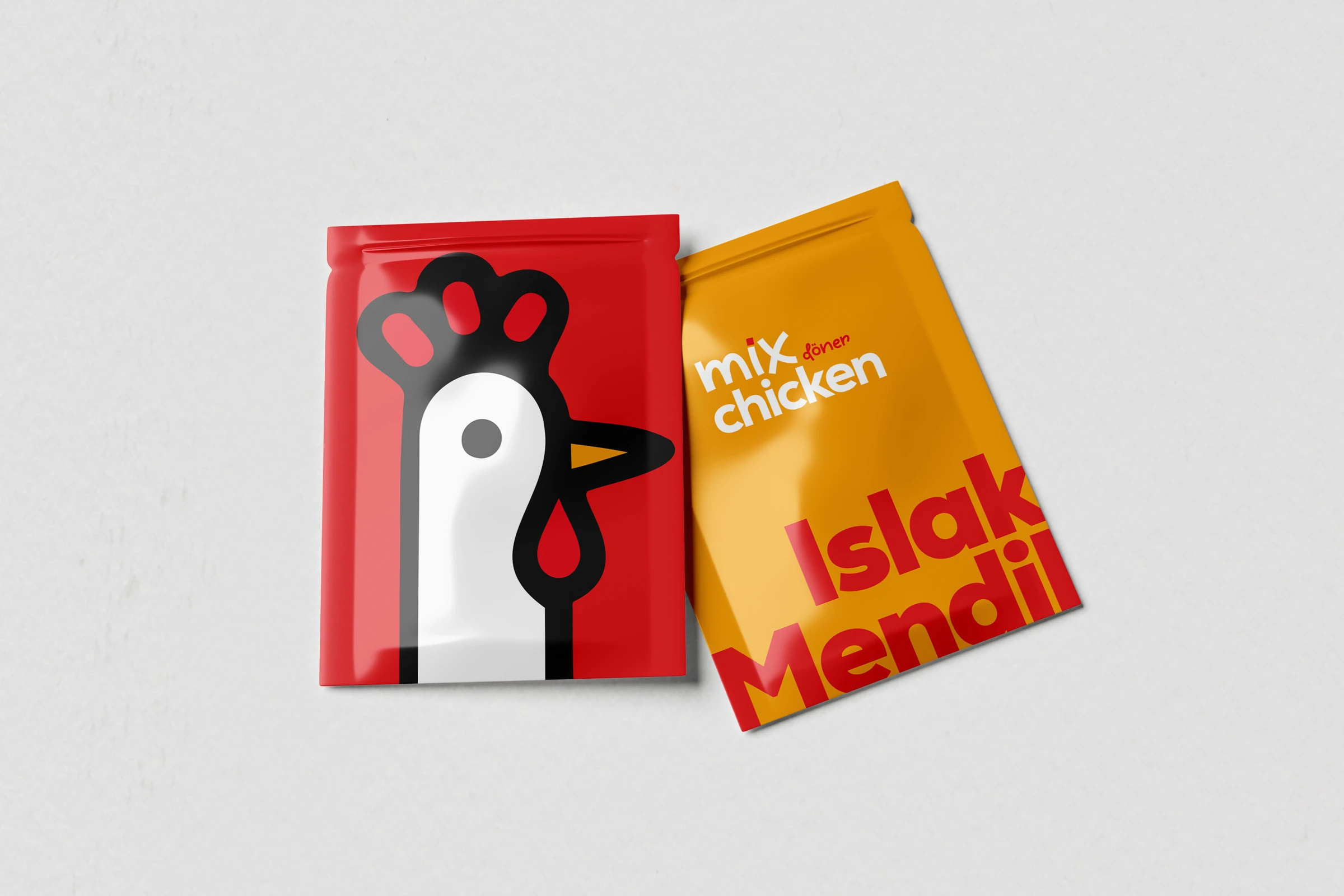 Kırmızı karakterli ve sarı “Islak Mendil” yazılı iki Mix Chicken ıslak mendil paketi